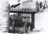 Siamo negli anni della ricostruzione 1946/7/8, si costruisce il nuovo ponte a monte del vecchio di circa 200mt,.sulle fondamenta del quale, è costruita la passerella pedonale. Nella foto si vede il muraglione e la passerella di legno. Per far posto al ponte saranno rimosse le macerie di alcune case
Gli uomini ritratti in questa foto sono: con la bicicletta Enzo Cecchi  presidente della cooperativa di ricostruzione, Terzani Enzo, e dietro sulla sinistra Giulio Casalini.